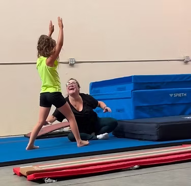 Recreational gymnast receiving encouraging coaching at Sandstorm